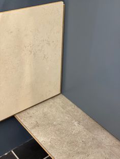 a bathroom with blue walls and white tile on the floor next to an empty mirror