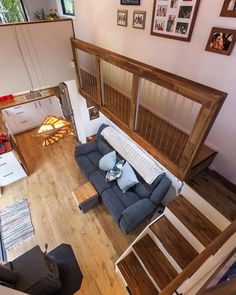 an aerial view of a living room with wood floors and blue couch in the center