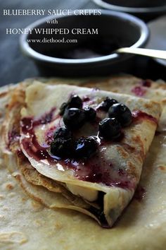 blueberry sauce crepes with honey - whipped cream are on top of each other