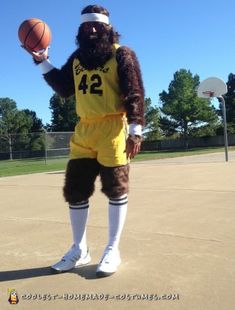 a man dressed as a basketball player holding a ball in one hand and wearing a monkey costume on the other