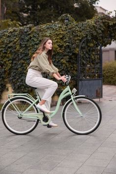 a woman riding on the back of a mint green bike