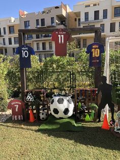 a soccer ball and jersey on display in front of an apartment building with lawn area