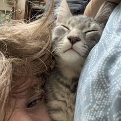 a woman holding a cat with her eyes closed