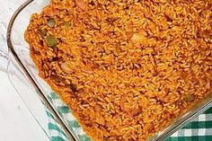 a glass casserole dish filled with rice and other food on a checkered table cloth