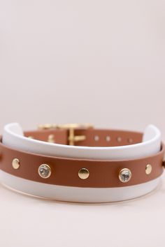 a white and brown leather dog collar with gold studs