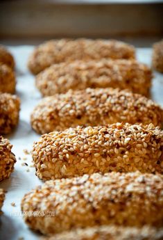 sesame sprinkled donuts on a baking sheet