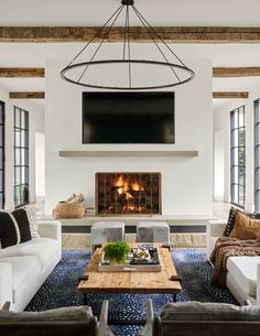 a living room filled with furniture and a flat screen tv mounted to the wall above a fireplace