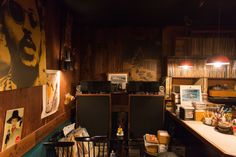 an old fashioned bar with posters on the wall and chairs in front of it at night