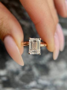 a woman's hand holding an engagement ring