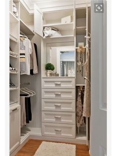 an organized closet with white drawers and shelves