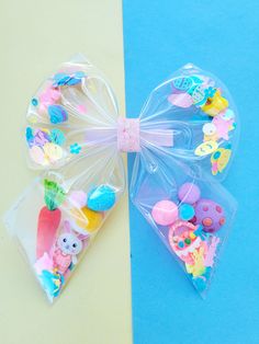 This Easter shaker bow is filled with all things Easter! This transparent material makes it possible to fill with soo many cute things it will be the most original bow anyone is wearing. Not only original, but very cute! Check out outfit shown in gallery here: https://lilysparklecreations.etsy.com/listing/1671837788/easter-shaker-tutu-bloomers-and-leotard Available on metal alligator clip, hair tie, satin lined headband, or nylon headband. Measures 6" wide x 6" tall. Emo Accessories, Fancy Bows, Bunny Egg, Cute Emo, Egg Basket, Crafty Kids, Transparent Material, Big Bow, Clip Hair