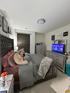 a bed room with a neatly made bed and a flat screen tv on the wall