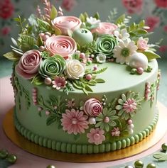 a green cake with pink and white flowers on it