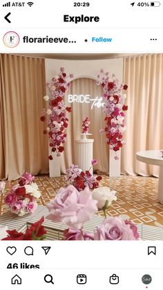 a table with flowers on it in front of a curtained entrance to a room