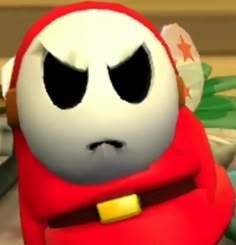 a close up of a cartoon character wearing a red outfit