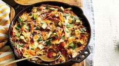 a skillet filled with food on top of a wooden cutting board