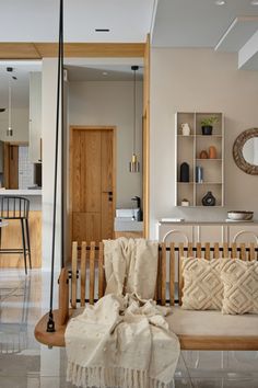 a living room filled with furniture next to a wooden table and bar stools in front of a kitchen