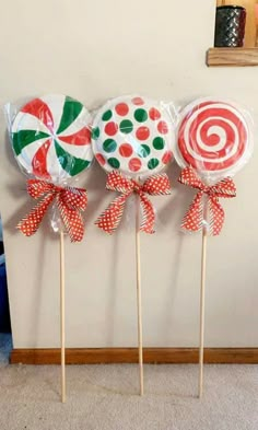 three lollipops are sitting on top of each other in front of a wall