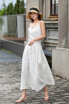 "This white linen midi skirt is perfect for adding a touch of vintage charm to your wardrobe! Featuring a row of buttons down the front and a flattering A-line silhouette, this skirt is both stylish and comfortable. Made from high-quality linen, it's perfect for keeping cool on warm days. Pair with a white blouse or a denim jacket for a chic and versatile look. DETAIL * 100% Linen * Two pockets * Back elastic waist * Button down skirt * Button front skirt * Below Knee Length * A Line skirt, Midi Buttoned Maxi Skirt For Spring, Spring Beige Skirt With Buttons, Summer Day Out Skirt With Buttons, Flowy Buttoned Maxi Skirt For Summer, Buttoned Skirt For Spring Beach Outings, Spring Buttoned Skirt For Beach, Spring Maxi Skirt With Buttons For Day Out, Spring Beach Skirt With Buttons, Chic Maxi Skirt With Buttons For Spring