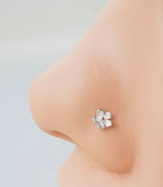 a close up view of a nose with an earring on it's side