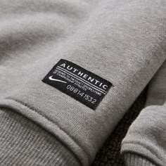 the back of a grey sweatshirt with a black tag on it