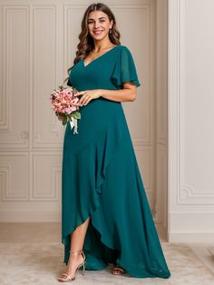 a woman in a green dress holding a bouquet and posing for the camera with her hands on her hips