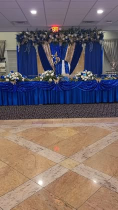 a banquet table with blue cloths and flowers on it