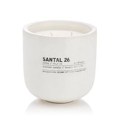 a white candle that is sitting in front of a white background with the words santal 26 printed on it