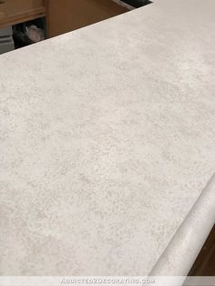 a white counter top in a kitchen with wooden cabinets