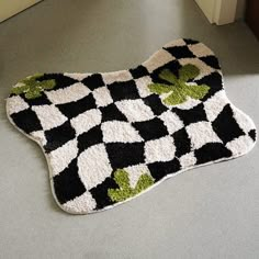 a black and white rug with green leaves on it