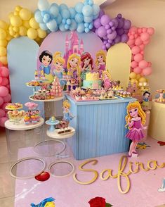 there is a birthday party with princesses on the table and balloons in the background