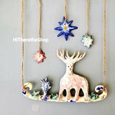 christmas ornaments hanging on a wall in the shape of deers and snowflakes