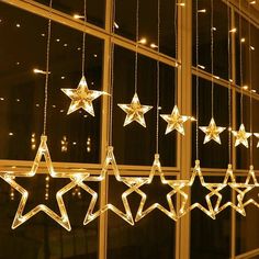 lighted stars hanging from the side of a window