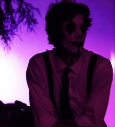 a man in a white shirt and black tie with his face painted like a clown