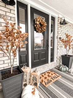 a front porch decorated for fall with pumpkins and other decorations