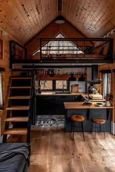 the interior of a tiny cabin with stairs leading up to it's loft bed