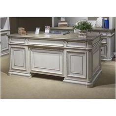 an office desk is shown with white cabinets and marble counter tops, along with bookshelves in the background