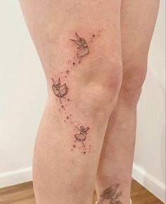 a woman's legs with tattoos on them and birds flying in the sky above her