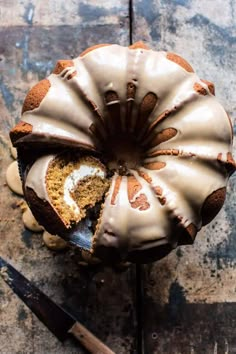 a bundt cake with frosting on top sitting next to a knife