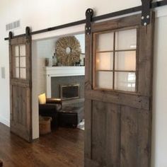 an open door leading to a living room with a fireplace in the corner and wood floors