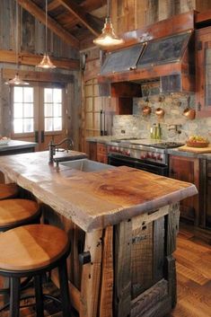 a rustic kitchen with wood floors and an island made out of wooden planks in the center