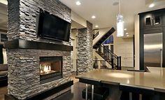 a living room filled with furniture and a flat screen tv mounted on the wall next to a fire place