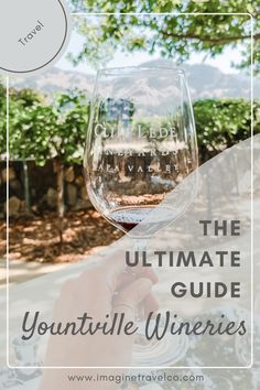 a person holding up a wine glass with the words, the ultimate guide to yountville