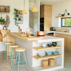 a kitchen filled with lots of counter top space and wooden stools next to it