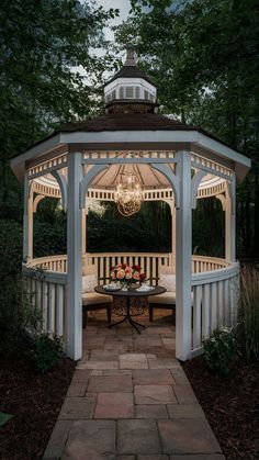 a white gazebo sitting on top of a brick walkway