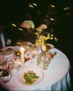 the table is set with flowers and candles for an elegant dinner or party in the dark