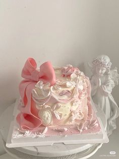 a pink and white cake sitting on top of a table