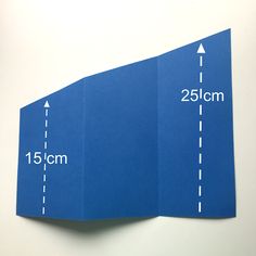 a blue folded piece of paper with the measurements for each side and an arrow pointing to the left