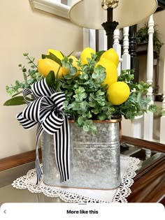 a metal bucket filled with yellow flowers on top of a table