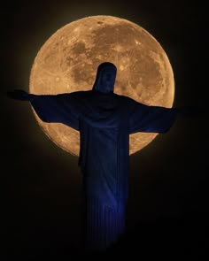 the statue of christ stands in front of a full moon